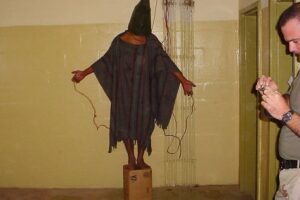 FILE - This late 2003 file photo, an image obtained by The Associated Press, shows an unidentified detainee standing on a box with a bag on his head and wires attached to him in the Abu Ghraib prison in Baghdad, Iraq. Amid violence like the attack in Paris on a satirical newspaper over its depictions of the Prophet Muhammad, there’s been increasing discussions among Muslims who say their community must re-examine their faith to modernize its interpretations and sideline extremists. Cherif Kouachi, one of the French brothers behind the Charlie Hebdo killings, appears to have been first radicalized by hearing of abuses of Iraqi inmates by American guards at Abu Ghraib prison. (AP Photo, File)
