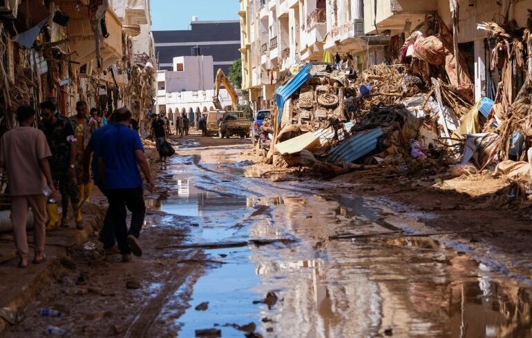 People walk in the mud between the rubbles, after a powerful storm and heavy rainfall hit Libya, in Derna, Libya September 13, 2023. REUTERS/Esam Omran Al-Fetori
