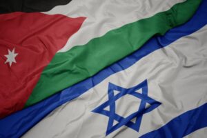 waving colorful flag of israel and national flag of jordan. macro